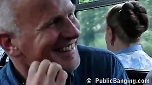 A young Caucasian woman performs oral sex on a man on a public bus.